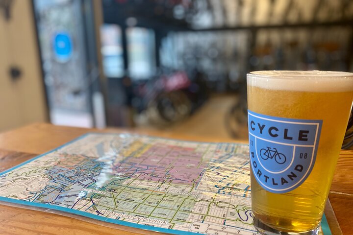 A glass of beer inside a Cycle Portland branded glass sitting on top of a map of Portland